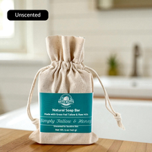 Load image into Gallery viewer, Bath Nutts raw milk &amp; tallow Soap Bar in a drawstring bag on a wooden surface with a bathroom background.