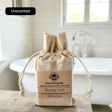 Load image into Gallery viewer, raw milk &amp; tallow soap bar in a drawstring bag on a wooden surface with a blurred background