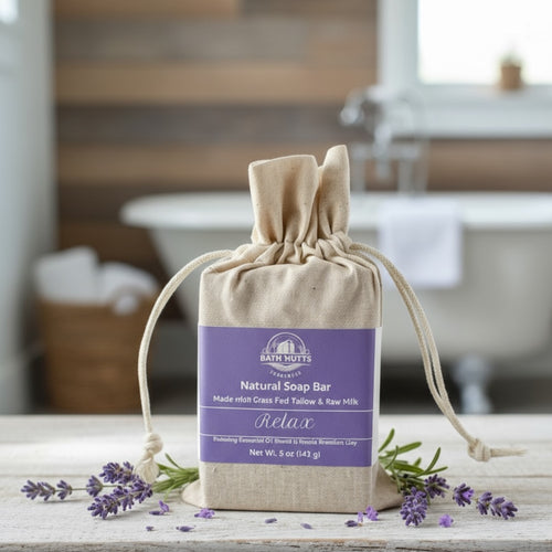 Bath Nutts natural soap bar in a drawstring bag with lavender flowers on a wooden surface.
