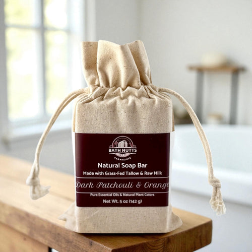 Bath Nutts natural soap bar in a drawstring bag on a wooden surface.