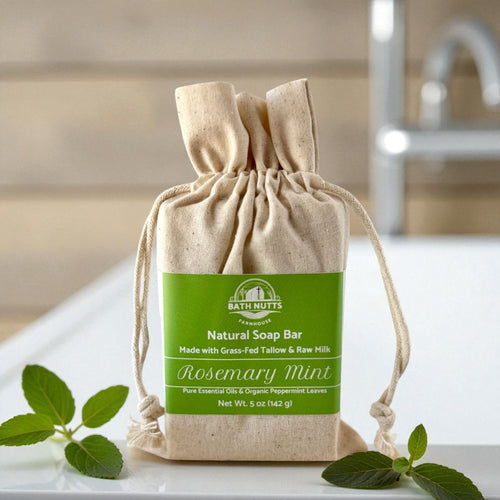 Bath Nutts natural soap bar in a drawstring bag with rosemary mint scent on a white surface.