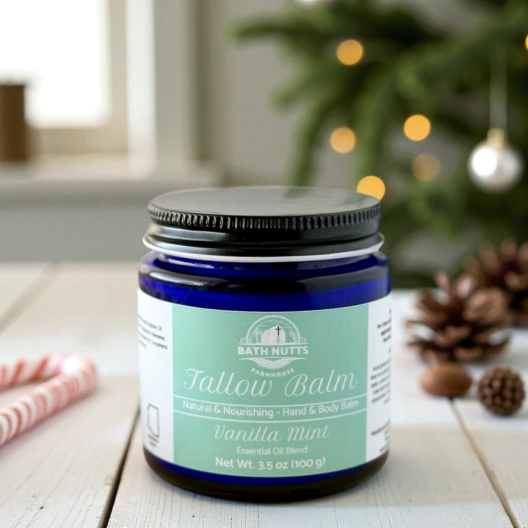 Bath Nutts Tallow Balm jar on a wooden surface with Christmas decorations in the background
