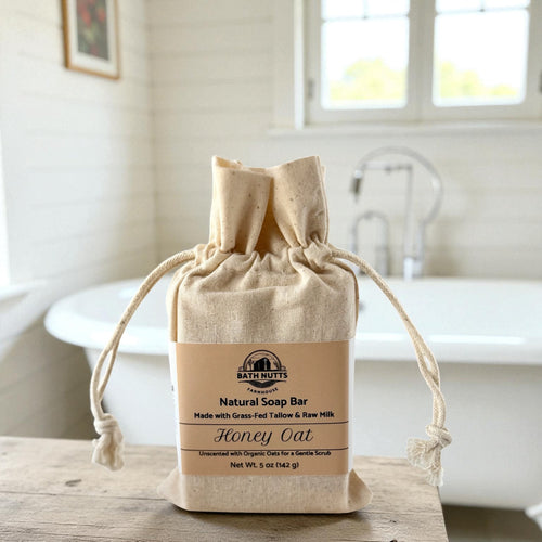Natural soap bar in a drawstring bag on a wooden surface with a blurred background
