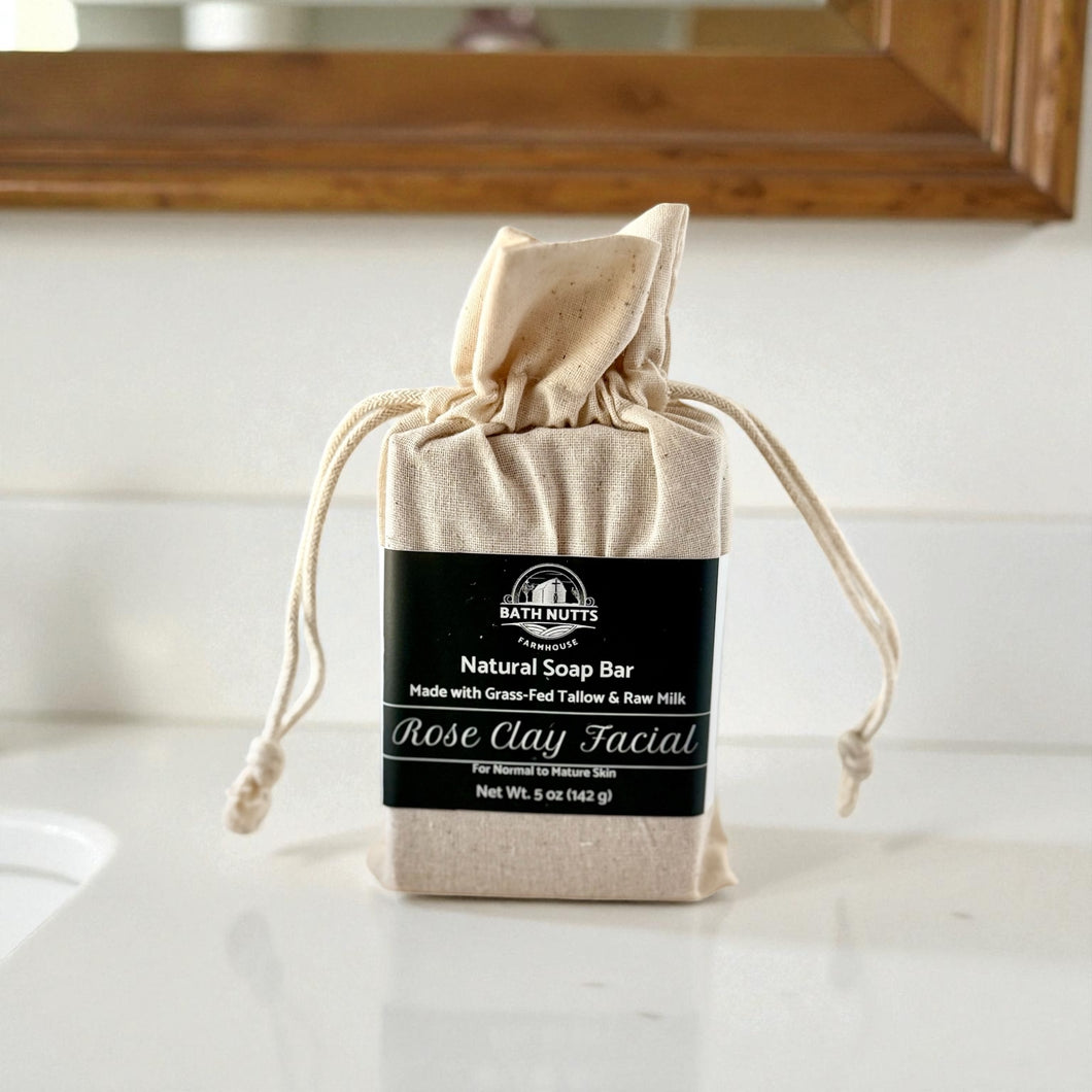 Bath Nutts natural rose clay facial soap bar in a drawstring bag on a bathroom counter.