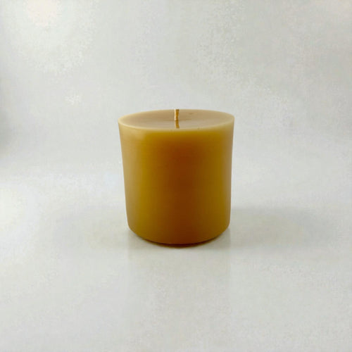 Pure beeswax candle on light gray background
