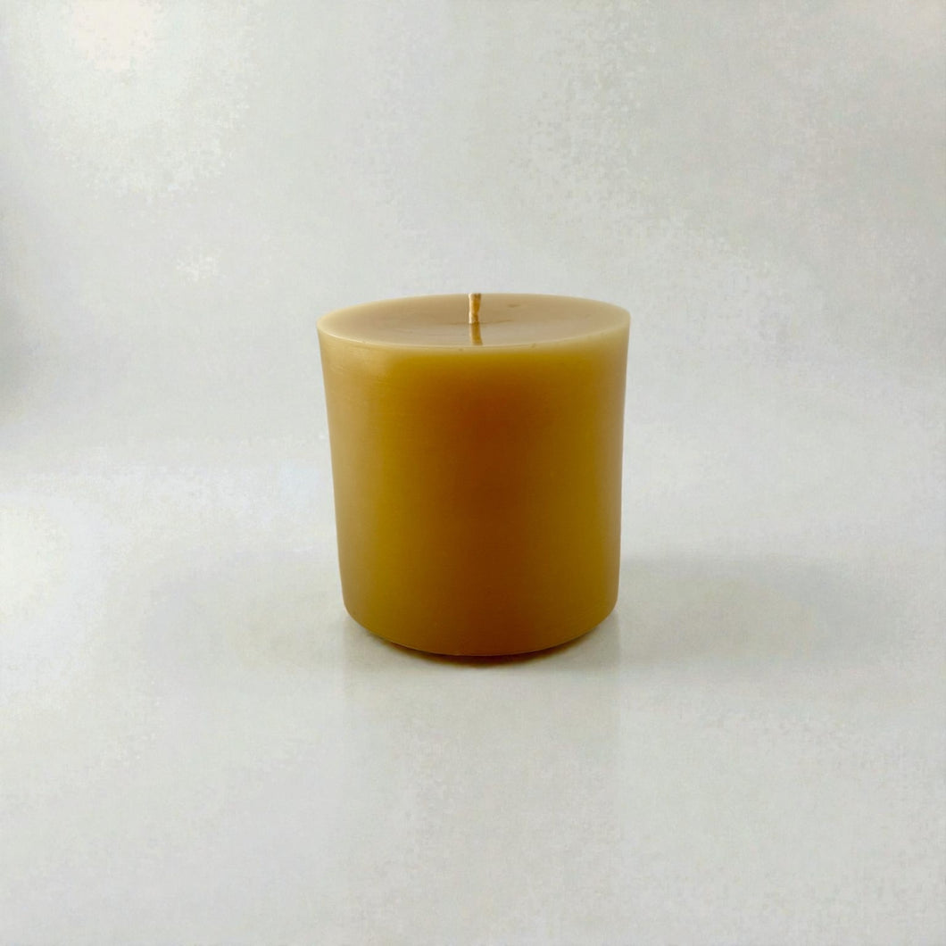 Pure beeswax candle on light gray background