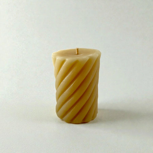 Pure beeswax candle, twisted pillar on white background