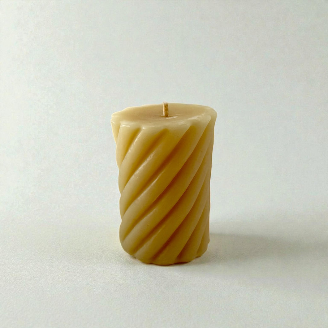 Pure beeswax candle, twisted pillar on white background